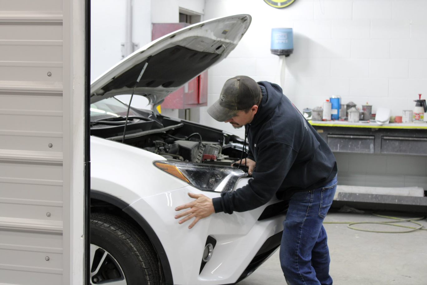 Technician working on a vehicle during collision repair